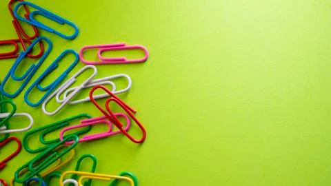 Paper clips on green background with copyspace. View from above with copy spa Stock Photos