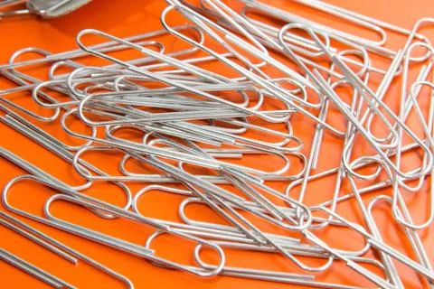 Paper clips to orange background Stock Photos