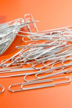 Paper clips to orange background Stock Photos
