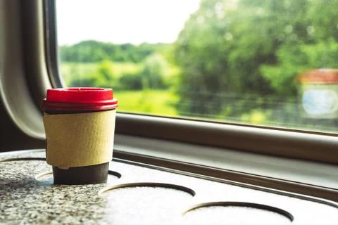 A paper coffee cup with a red plastic lid and a white inscription circle 스톡 사진