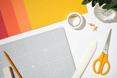 Paper crafting tools background. Gray cutting mat, orange scissors, colorfu.. Stock Photos