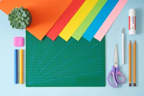 Paper crafts work table top view. Tools green cutting mat, scissors, office.. Stock Photos