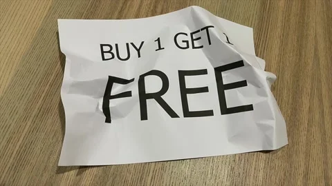 Paper crumpled into ball in stop motion paper printed "BUY 1 GET 1 FREE" Stock Footage 172355625