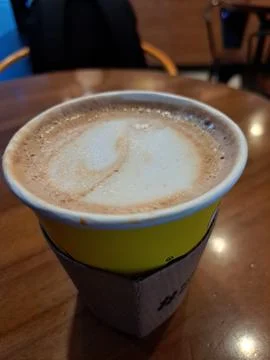 A Paper Cup of Hot Caffe Latte Served on Wooden Table at Coffee Shop Stock Photos