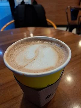 A Paper Cup of Hot Caffe Latte Served on Wooden Table at Coffee Shop Stock Photos