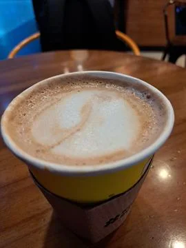 A Paper Cup of Hot Caffe Latte Served on Wooden Table at Coffee Shop Stock Photos