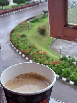 A Paper Cup of Hot Coffee by the Window with Rainy Garden View in Berastagi Stock Photos