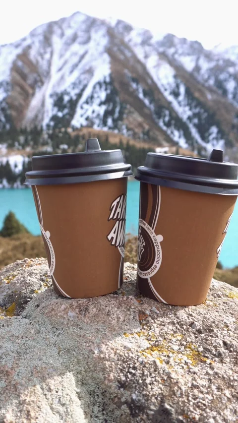 Paper cups on the background of a mountain lake Vídeos de archivo 230084146