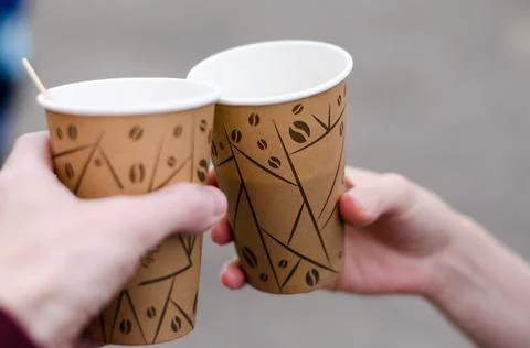 Paper cups with coffee in hands close-up. Hands hold glasses with coffee Stock Photos