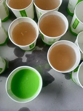 Paper cups with colored liquids on surface Fotos Stock