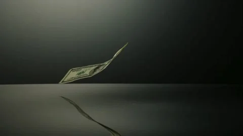 Paper currency notes falling from above onto a dark mirror surface Stock Footage 326625875