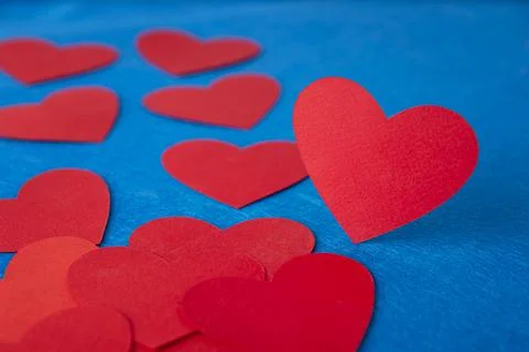 Paper cut red hearts shape on blue textured background with copy space. Conce Stock Photos