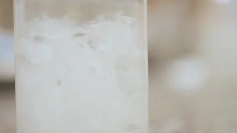 Paper cut was thrown into a flask of water and dissolved by stirring . Stock Footage 308717235