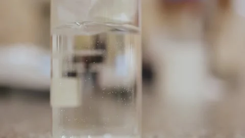 Paper cut was thrown into a flask of water and dissolved by stirring . Stock Footage 308717256