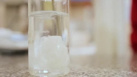 Paper cut was thrown into a flask of water and dissolved by stirring . Stock Footage 308717391