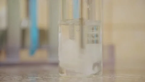 Paper cut was thrown into a flask of water and dissolved by stirring Stock Footage 308718585