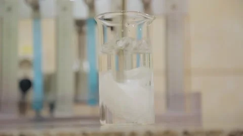 Paper cut was thrown into a flask of water and dissolved by stirring Stock Footage 308718609