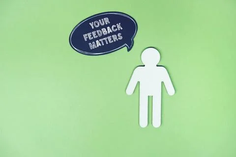 Paper Cutout Figure with Feedback Speech Bubble on Green Background Stock Photos