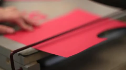 Paper cutter cutting red paper Stock Footage 10579876