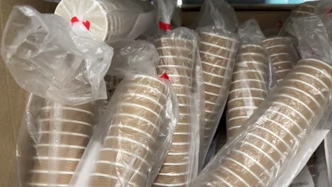 Paper dishes Disposable plastic cups packaged in clear bags and cardboard boxes Stock Footage 345173336