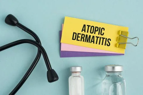A paper displaying the words Atopic Dermatitis, clipped with a yellow binde.. Stock Photos