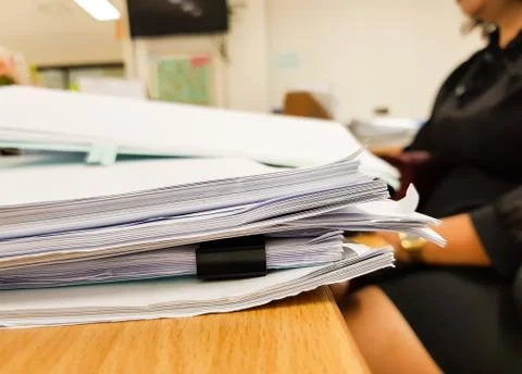 Paper document on desk with blur working woman,office concept background Stock Photos