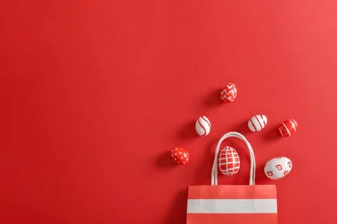 Paper eco-bag with painted Easter eggs on a red background. Banner for a happ Stock Photos