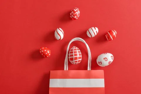 Paper eco-bag with painted Easter eggs on a red background. Stock Photos