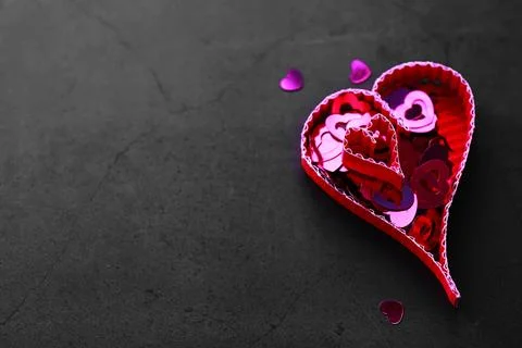 Paper elements in shape of heart on dark stone background. Love Valentine's.. Foto stock
