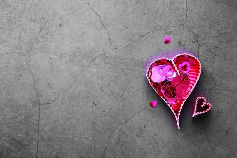 Paper elements in shape of heart on dark stone background. Love and Valentine Stock-Fotos