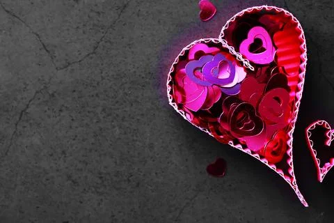 Paper elements in shape of heart on dark stone background. Love and Valentine Stock-Fotos