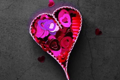 Paper elements in shape of heart on dark stone background. Love and Valentine Foto stock