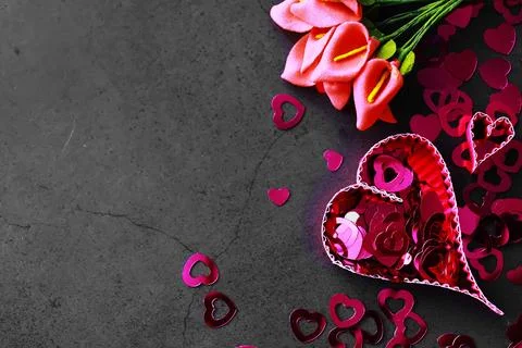 Paper elements in shape of heart on dark stone background. Love and Valentine Foto stock