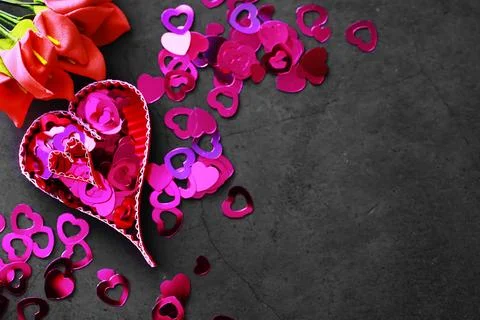 Paper elements in shape of heart on dark stone background. Love and Valentine Foto stock