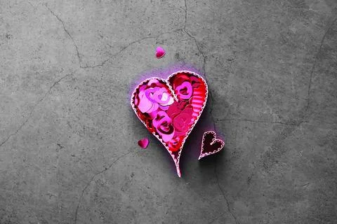 Paper elements in shape of heart on dark stone background. Love and Valentine Foto stock