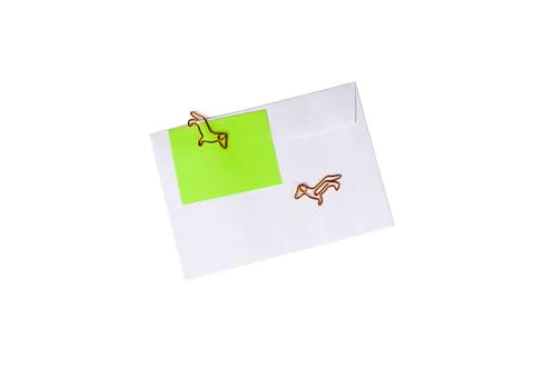 Paper envelope with blank note and dog-shaped paper clip on white background. Stock Photos