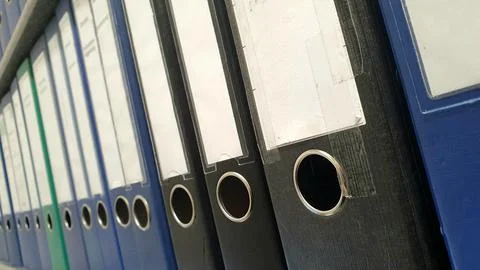 Paper folder in a row with different colors on a office shelf. Stock Photos