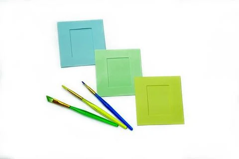 Paper frames and brushes for drawing different colors on white background. Stock Photos