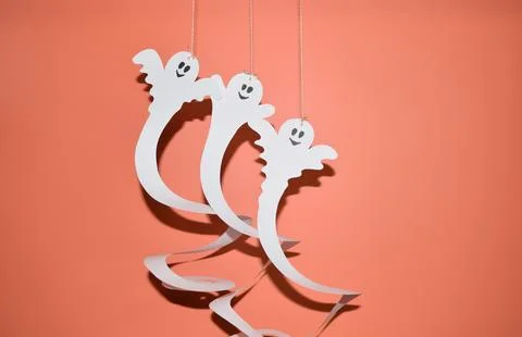 Paper ghosts on an orange background Stock Photos