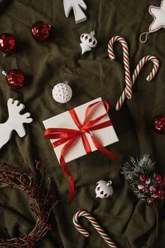 Paper gift box with bow tie and Christmas stuff: baubles, candy canes, toys o Fotos de archivo