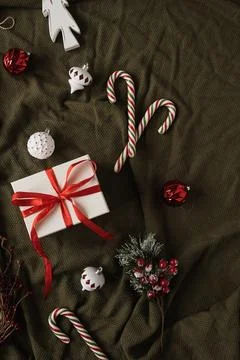 Paper gift box with bow tie and Christmas stuff: baubles, candy canes, toys o Fotos de archivo