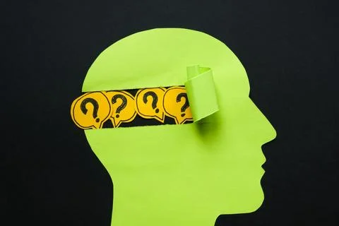 A paper head with question marks. Uncertainty and the search for answers. Stock Photos