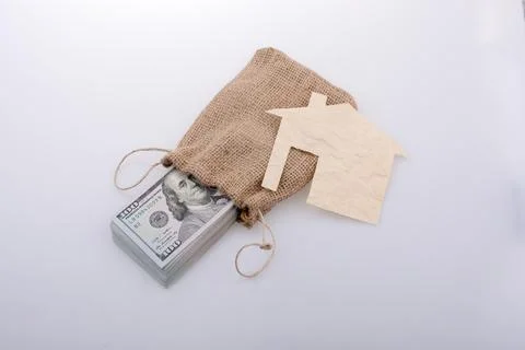 Paper house placed beside a bundle of US dollar banknote Stock Illustration