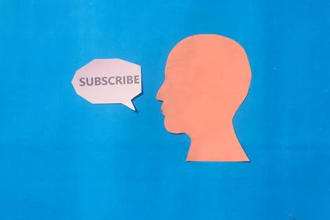 Paper Human face with Subscribe word on speech bubble isolated on blue backgr Foto stock