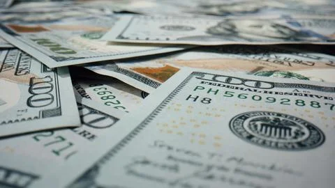 Paper hundred dollar bills on surface close up. American currency scattered. Stock Photos