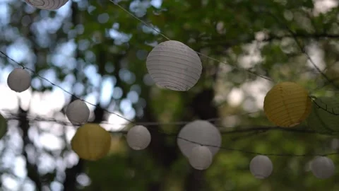 Paper Lanterns Hanging on String with Trees in Background Stock Footage 318354911