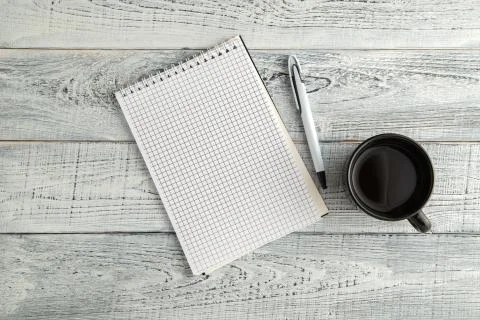 Paper notebook,pen and Cup of tea or coffee on vintage shabby white wooden ba Stock Photos