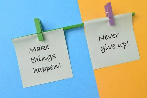 Paper notes with phrase MAKE THINGS HAPPEN! and NEVER GIVE UP! Stock Photos