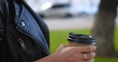 Paper or plastic cup of coffee in the hand of a girl  walking 動画素材 116539255