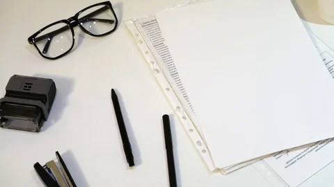 Paper, pen, stapler and glasses on a white table Video stock 83467390
